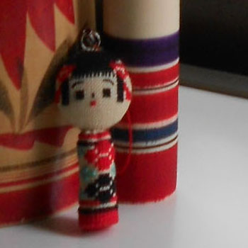 Close up on little cross stitched kokeshi doll