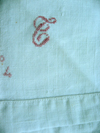 An antique bedsheet with cross stitched monogam and numbering